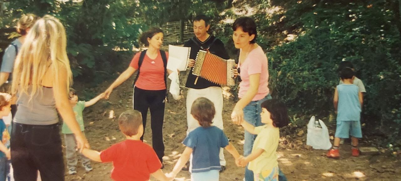 Un girotondo di bambini e adulti all'aperto